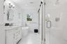 Bathroom featuring a shower stall, a freestanding bath, visible vents, vanity, and wainscoting