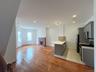 Kitchen featuring stainless steel appliances, gray cabinets, a peninsula, light countertops, and a brick fireplace