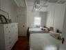 Bedroom featuring beamed ceiling, dark wood-style flooring, and ceiling fan