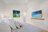 Guest bedroom with original artwork and flat screen TV