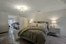 Bedroom with crown molding, a notable chandelier, and dark colored carpet