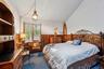 Bedroom with wood walls, a wainscoted wall, dark colored carpet, and lofted ceiling