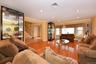 Living room with a baseboard radiator, wood-type flooring, and crown molding