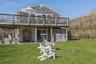 Rear view of house featuring a deck, a lawn, and stairs