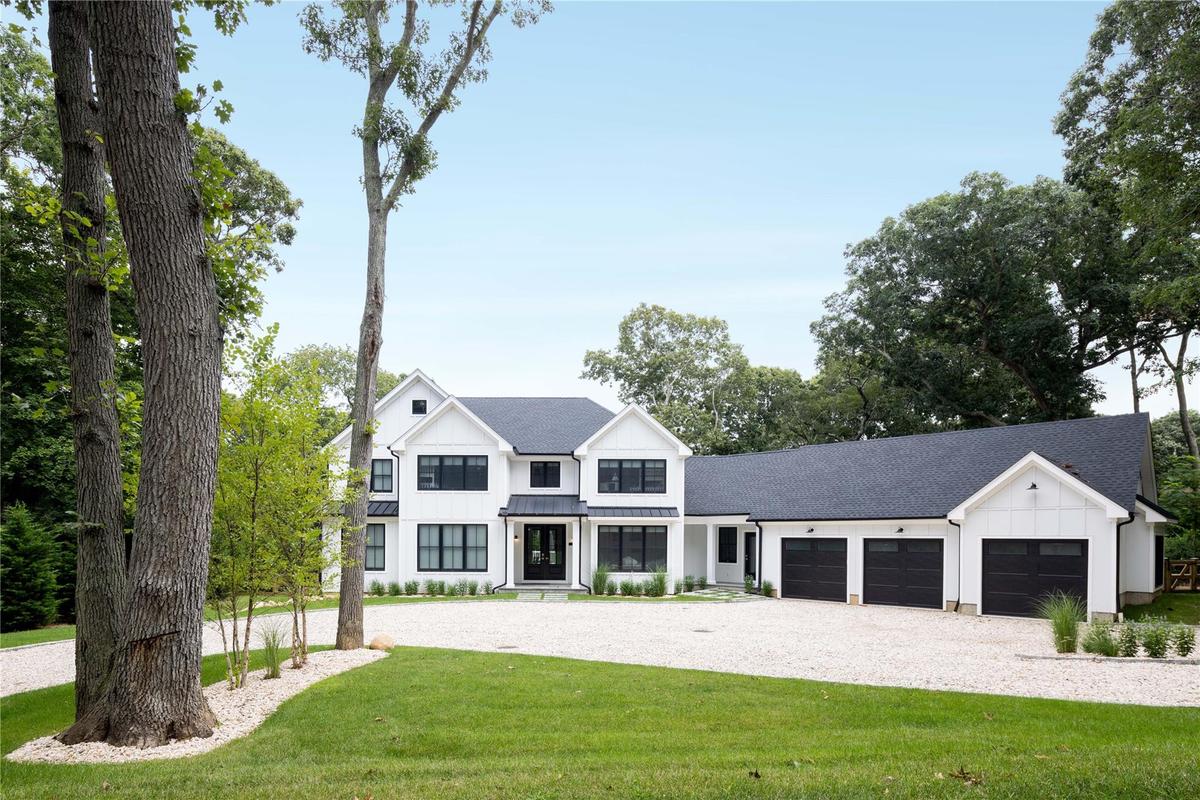 Modern farmhouse style home with board and batten siding, an attached garage, driveway, a front lawn, and a shingled roof