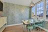 Dining space with wallpapered walls, light wood-style flooring, and a chandelier
