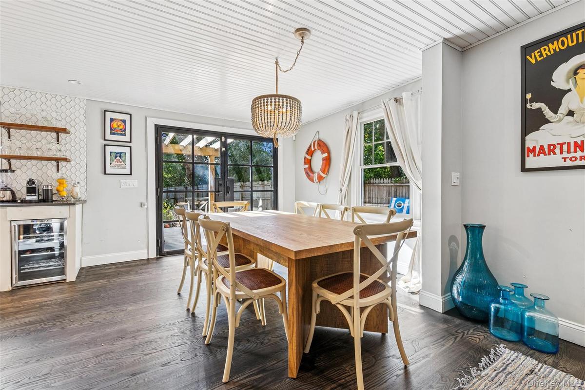 Dining room with beverage cooler, dark wood-style flooring, and a chandelier