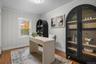 Flexible home office with hardwood floors, crown molding, and natural light creating an ideal workspace or study area.