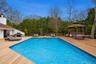 Expansive outdoor living area featuring a heated, gunite pool and a built-in gazebo