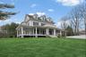 Farmhouse inspired home with a porch and a front lawn
