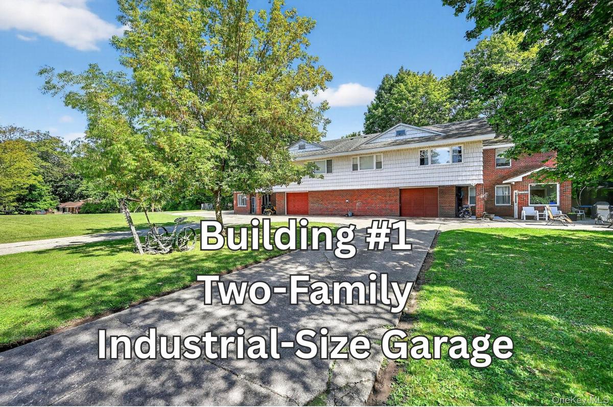 View of front facade featuring brick siding, a front lawn, driveway, and a garage