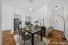 Parquet wood-finish flooring extends throughout this interior space, featuring a recessed kitchen with upper and lower cabinetry