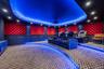 Carpeted cinema room with a tray ceiling, a decorative wall, and recessed lighting