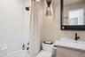 Bathroom featuring vanity, shower / tub combo, and tile walls