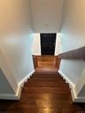 Hardwood staircase with natural wood balusters and a dark wood handrail