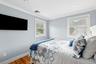Bedroom with crown molding, wood finished floors, and recessed lighting