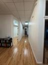 Hallway with light wood-style floors and a paneled ceiling