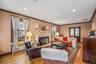 Living room with a premium fireplace, wood-type flooring, radiator heating unit, ornamental molding, and recessed lighting