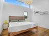 Bedroom with wood finished floors and a high ceiling