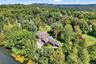 View from above of property featuring a nearby body of water and a heavily wooded area