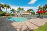 Freeform heated pool and elevated overflow spa surrounded by paver patio.