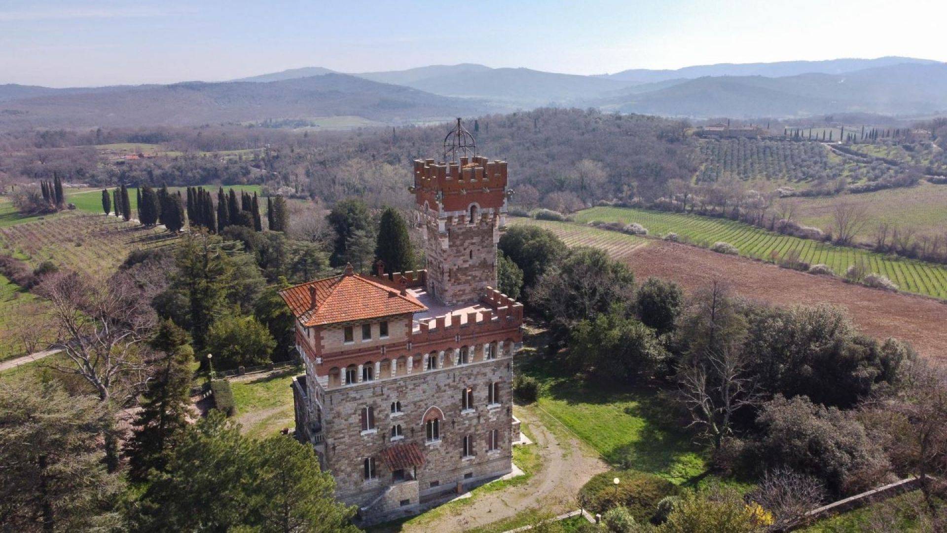 Art Nouveau villa in neo-medieval style with tower and panoramic terraces, vineyards, for sale in the Chianti region between Siena and Arezzo.