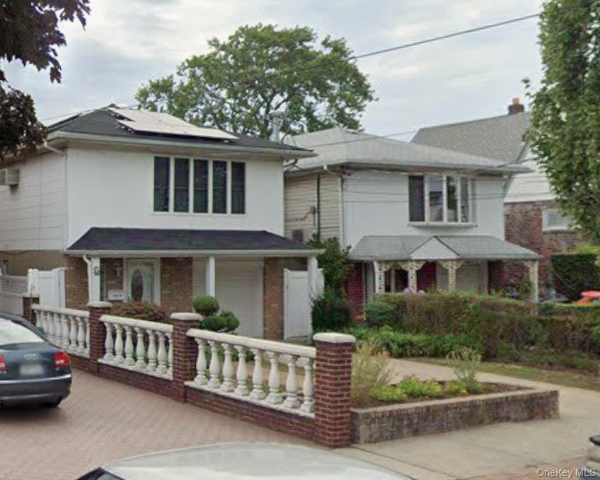 Traditional style home featuring roof mounted solar panels, covered porch, and driveway