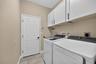 Laundry area with built in cabinets, laundry tub and leads into the 3 car garage