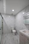 Bathroom with a marble finish shower, tile walls, marble tiled floors, vanity, and recessed lighting