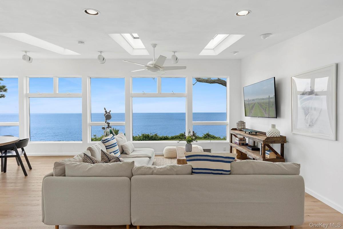 Living room featuring light wood-style flooring, healthy amount of natural light, recessed lighting, ceiling fan, and a skylight