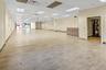 Unfurnished room with a drop ceiling, light wood-style flooring, and electric water heater