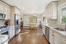 Kitchen featuring stainless steel appliances, light stone counters, a chandelier, hanging light fixtures, and recessed lighting