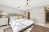 Bedroom with light wood-style flooring, vaulted ceiling, and connected bathroom