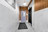 Entryway with elevator, tile patterned floors, and tile walls