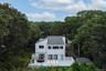 Back of property with a view of trees and a chimney