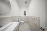Bathroom with tile walls, a wainscoted wall, vanity, and marble finish flooring