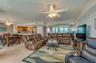 The spacious open-concept design combines living, dining, and kitchen areas, offering coastal views, recessed lighting, and a mirrored accent wall tha