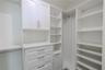 Bedroom 3 walk-in closet is thoughtfully designed with built-in shelving, drawers, and hanging space, providing both beauty and function. Soft-close c