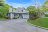 Contemporary exterior with an attached garage, a paved driveway, and manicured landscaping