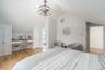 Bedroom with lofted ceiling, light wood-type flooring, and a chandelier