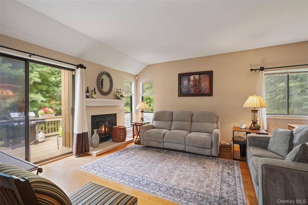 Formal living room with wood-burning fireplace and sliders to the backyard deck