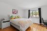Bedroom with light wood-type flooring, ornamental molding, and a desk
