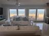 Living room with wine cooler, light tile patterned floors, ornamental molding, ceiling fan, and a water view