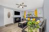 Living area with light wood finished floors and a ceiling fan