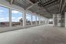 Unfurnished sunroom featuring unfinished concrete floors and a view of skyline