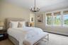 Bedroom featuring multiple windows, a chandelier, and wood finished floors