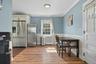 Kitchen with stainless steel fridge with ice dispenser, freestanding refrigerator, light wood-style flooring, ornamental molding, and radiator heating