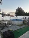 View of pool featuring a wooden deck, a patio, and outdoor dining area