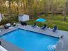 Outdoor pool featuring a deck, a yard, a grill, and a storage shed