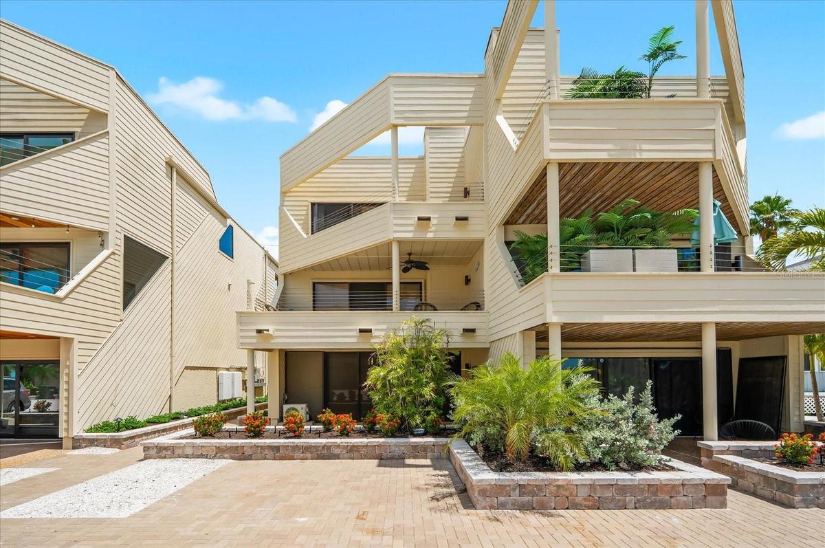 Back of townhome with parking space and covered porch